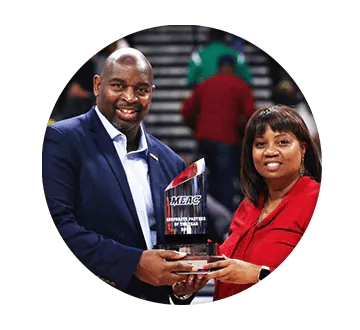 Circle shaped image of a man and woman holding a MEAC crystal style award